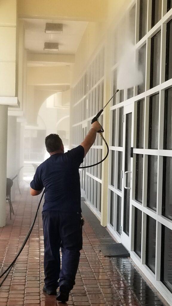 Reedley retail storefront entry with gum spots and traffic grime on the concrete before cleaning.