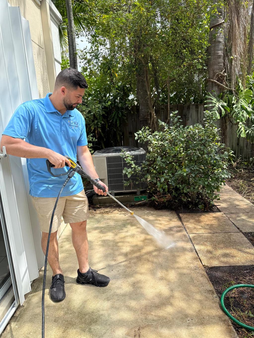 Valley Concrete technician pressure washing a backyard concrete patio.