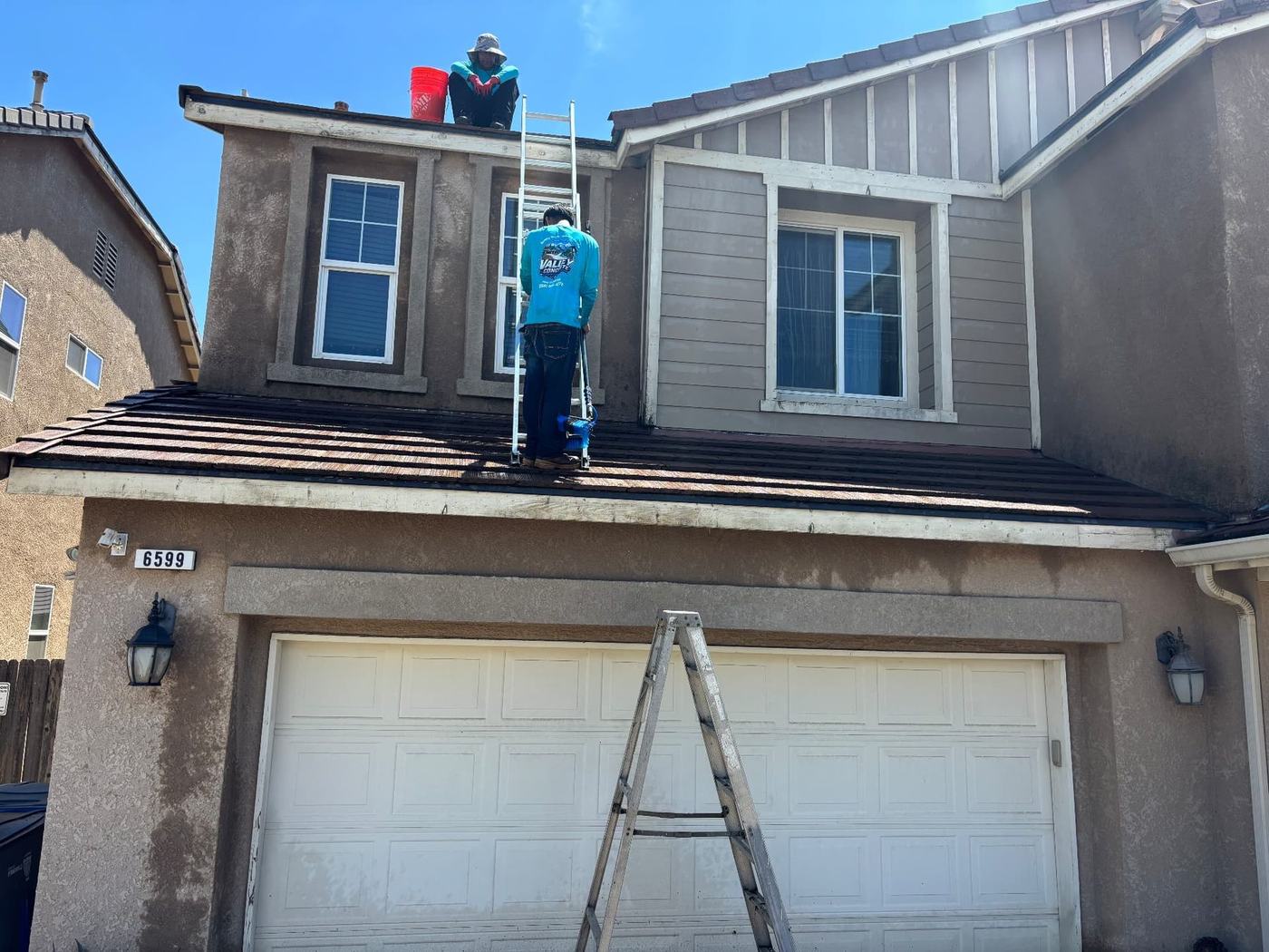Valley Concrete Pressure Washing crew on ladders soft-washing the upper level of a two-story home.
