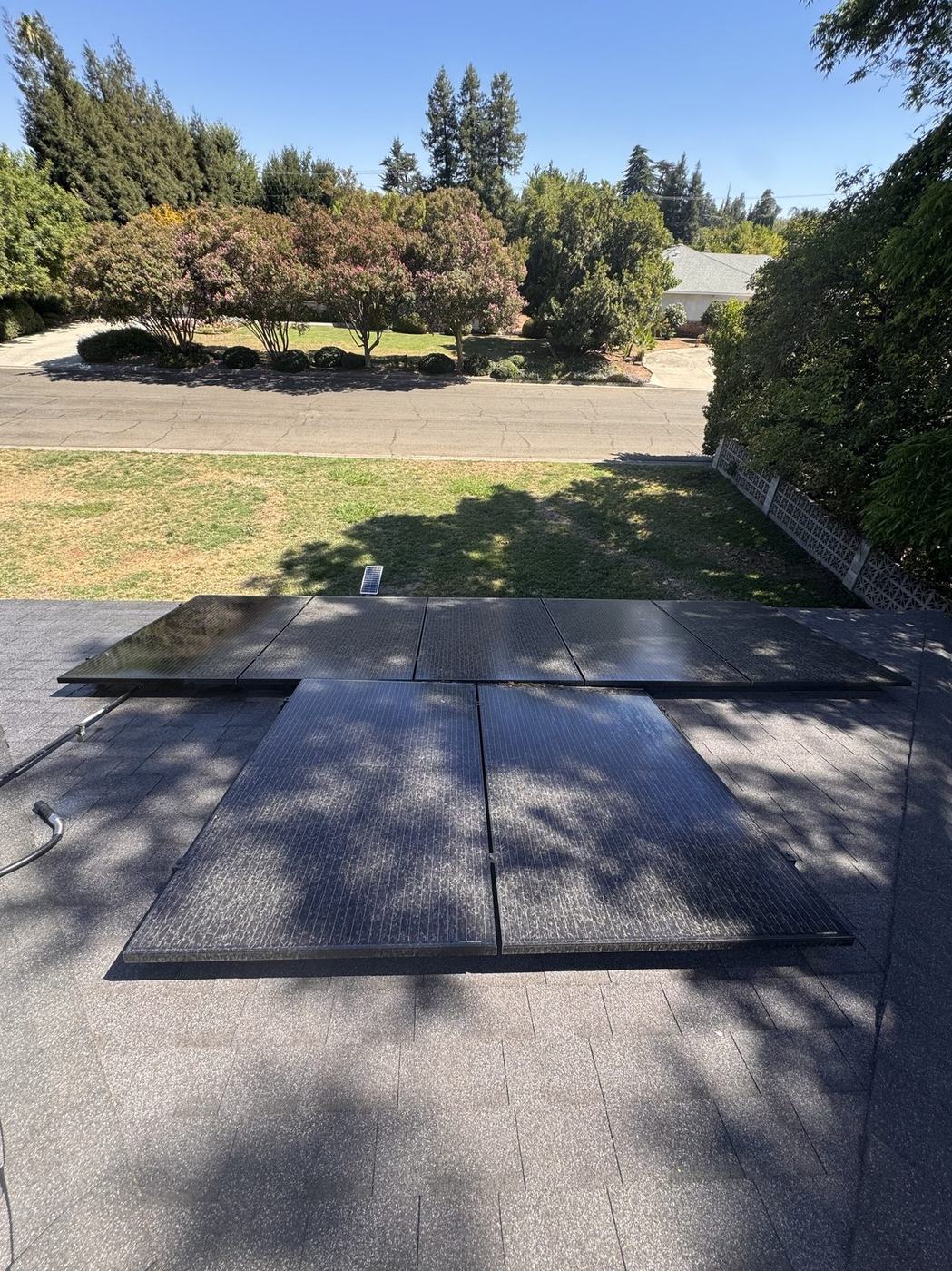Ground-mounted solar panels cleaned to a spotless finish in a residential backyard.
