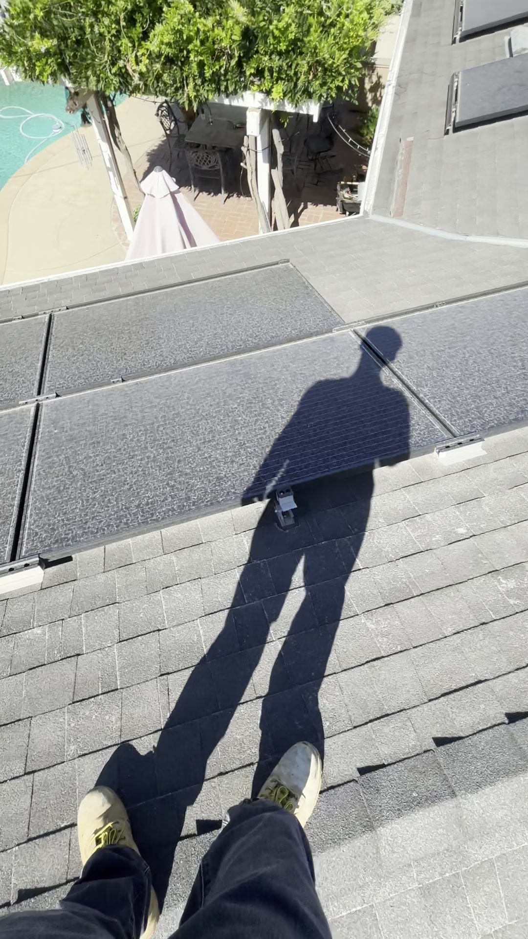 Freshly cleaned rooftop solar panels above a well-kept residential property and yard.