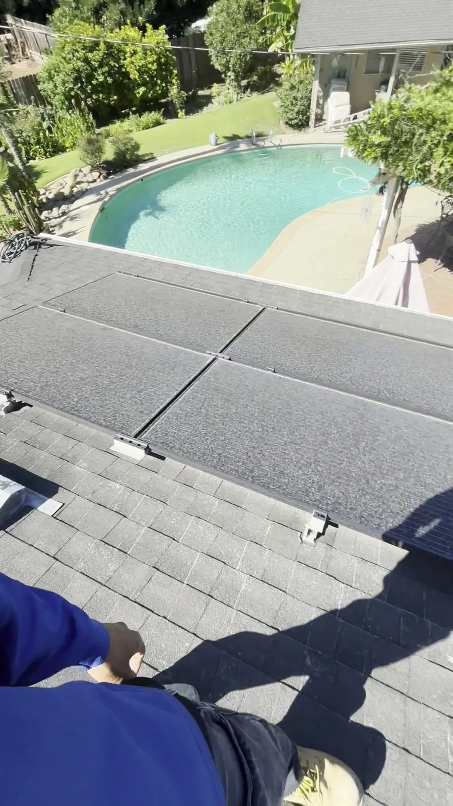 Clean rooftop solar array overlooking a landscaped backyard and swimming pool on a premium home.