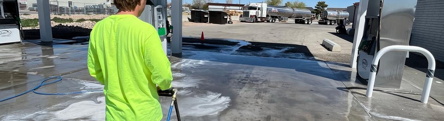 Commercial fuel island and concrete pad being degreased and washed clean during daytime service.