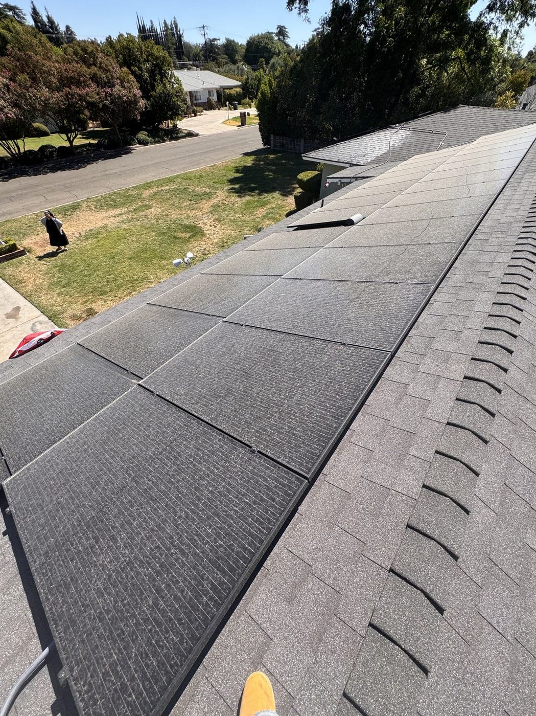 Wide shot of a large solar array on a shingle roof after a full soft-wash cleaning.