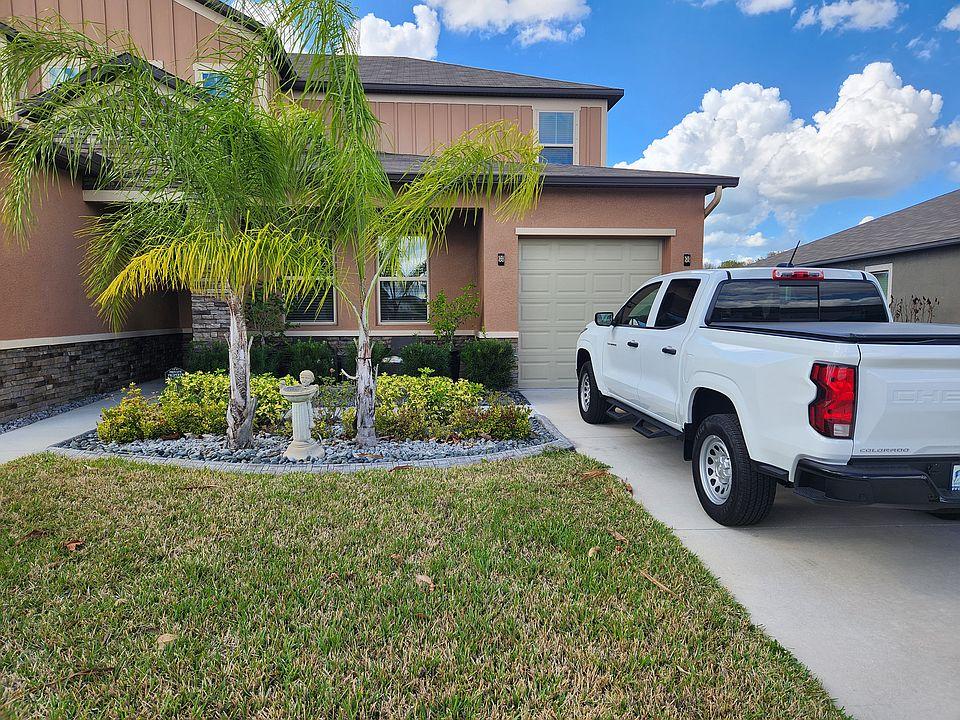 Well-kept home exterior with clean driveway and tidy front landscaping.
